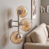 Modern globe wall light Koyoto with three amber glass shades on a sand-coloured metal bar