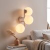 Modern globe wall light Gastor with three white glass shades for the couch